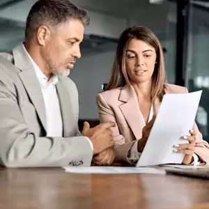 two business people’s hands next to a silver laptop